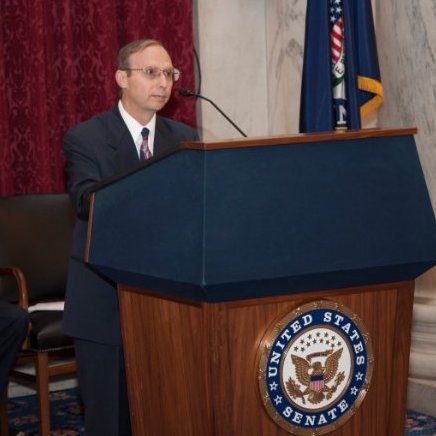 Michael Ellenbogen stands speaking at a podium.