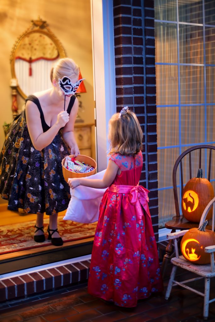 Woman gives candy to a young trick or treater