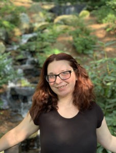 Image of Hannah Posing in Front of a Forest Background.