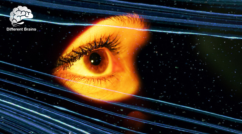 A closeup of an eye surrounded by darkness and streaks of light