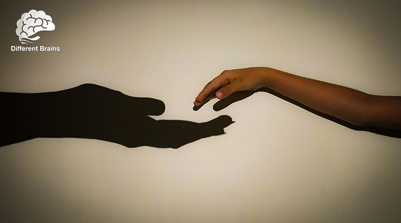 A child's hand reaches out for an adult hand that isn't there, represented by a shadow on the wall