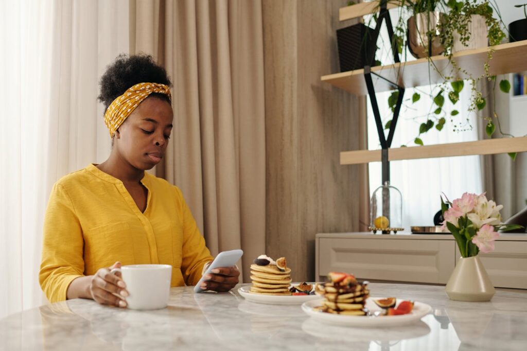 a woman having breakfast and looking at her phone