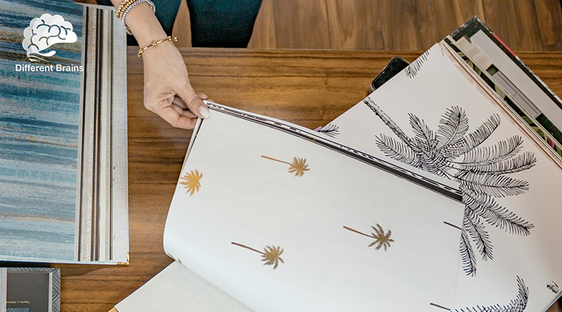 A person flips through a book of wallpaper samples